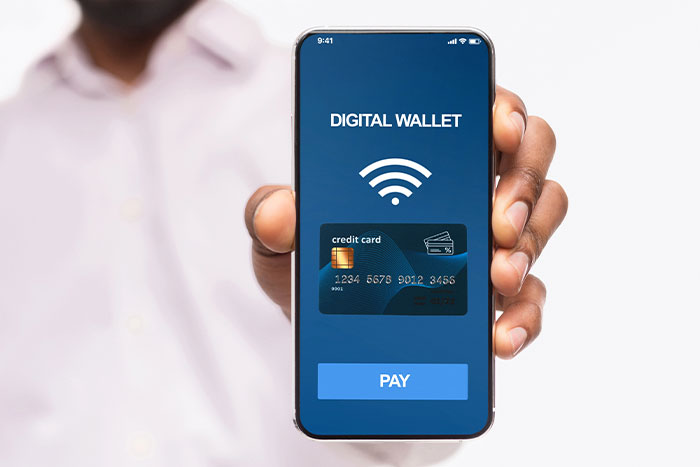 Photo of someone holding up a smartphone that says digital wallet.
