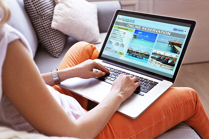 Woman on laptop, booking a trip.