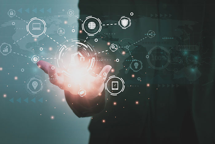 A hand interacts with a virtual interface displaying networked technology icons.